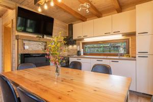 a kitchen and dining room with a wooden table and chairs at Forest Princess Chalet - Happy Rentals in Nova Vas