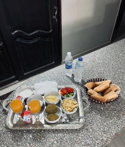 uma bandeja de comida num balcão com comida e bebidas em Aoda pyramids em Cairo