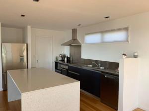 una cocina con encimera y refrigerador en Modern executive house, stunning views over Hobart, en Sandy Bay