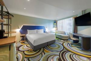 a hotel room with a bed and a television at Adge Hotel and Residence - Adge King - Australia in Sydney