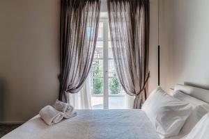 a bedroom with a white bed with a window at LA TERRAZZA - Downtown Como - Terrace and Jacuzzi in Como