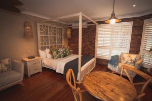 a bedroom with a bed and a table and chairs at Ballina Palms Boutique Motel in Ballina