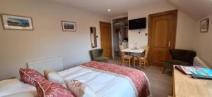 a bedroom with a bed and a table and a desk at Caisteal Liath House in Lochinver