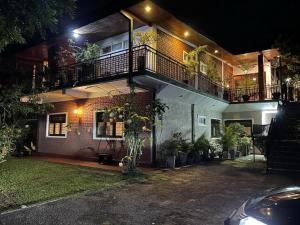 a house with a balcony with plants on it at night at The Tenthola in Kandy