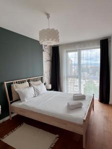 ein Schlafzimmer mit einem Bett mit einem großen Fenster in der Unterkunft Homeland City View in Cluj-Napoca + 16 Fotos