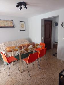 a dining room with a table and orange chairs at La viña de camarata in Aguilar de la Frontera