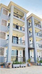 un grand immeuble d'appartements avec balcon et plantes dans l'établissement Serene Apartments, à Bulindo