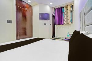 una camera da letto con un grande letto bianco e una finestra di OYO Flagship Starx Inn a Nuova Delhi