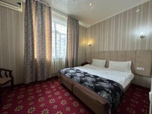 Habitación de hotel con cama y ventana en ОРДА en Shymkent