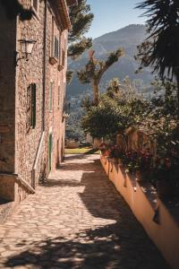 a stone alley with flowers on the side of a building at Sa Pedrissa in Deia