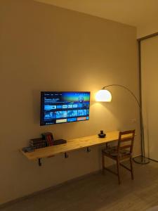 a desk with a television on a wall with a chair at lake dreams in Verbania