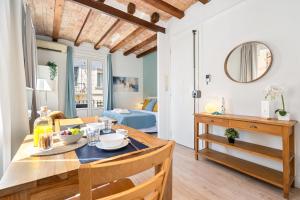 a dining room and living room with a table and chairs at Lodging Apartments Barceloneta Beach Studio 32 in Barcelona