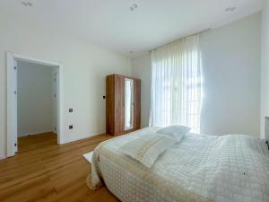 - une chambre blanche avec un lit et une fenêtre dans l'établissement White Harmony House, à Şamaxı
