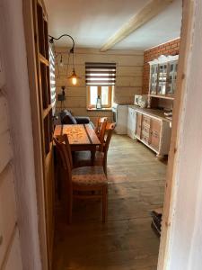 a dining room with a table and chairs in a kitchen at Domki w Bieszczadach Cisna in Cisna