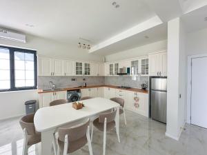 a white kitchen with a white table and chairs at White Harmony Houses in Shamakhi