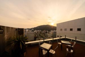 d'un balcon avec des chaises et une vue sur la ville. dans l'établissement Hotel Sunroute Tokushima, à Tokushima