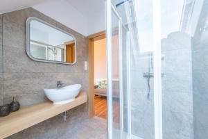 ein Bad mit einem Waschbecken und einem Spiegel in der Unterkunft Weingut Dietl in Riegersburg