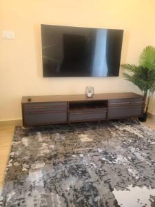sala de estar con TV grande en la pared en Living Spaces Apartments, en Lusaka