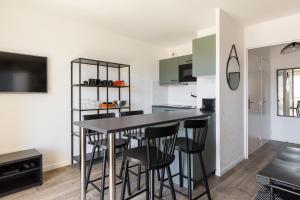 里昂的住宿－L'élégant - Desaugiers，厨房以及带桌椅的用餐室。