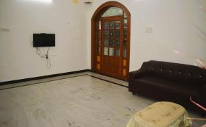a living room with a couch and a door at Golden Gate Serviced Apartment in Chennai