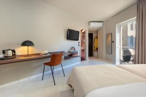 a bedroom with a bed and a desk with a chair at Hotel Nafpaktos in Nafpaktos