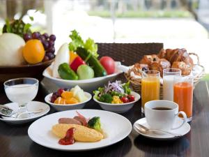 a table topped with plates of food and bowls of fruit at Hotel Nikko Fukuoka in Fukuoka