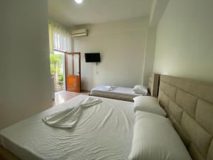 een slaapkamer met 2 bedden en een tv aan de muur bij Guesthouse SELI in Berat