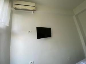 TV en una pared blanca en una habitación en Guesthouse SELI, en Berat