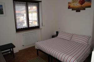 een kleine slaapkamer met een bed en een raam bij IL PAITITI in Arco