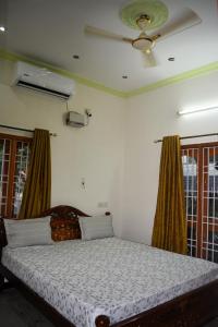 a bedroom with a bed and a ceiling fan at Golden Gate Serviced Apartment in Chennai