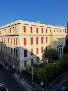 a large building with red windows on a street at Athenian Modern 2BD Apt next to Metro Panepistimio in Athens