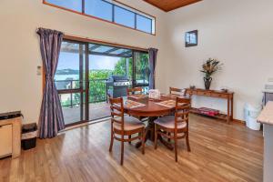 - une cuisine et une salle à manger avec une table et des chaises dans l'établissement Seascape Sanctuary - Okiato Holiday Home, à Russell