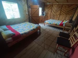 - une chambre avec 2 lits dans une cabane en bois dans l'établissement Ibankordor Jungle Resort, à Cherrapunji