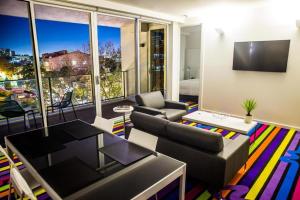 een woonkamer met een bank en een tafel bij Adge Hotel and Residence - Adge Queen - Australia in Sydney