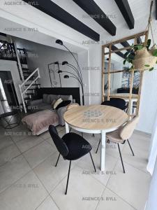 een kamer met een tafel en stoelen en een bed bij Résidence Héliovillage - Maisons & Villas pour 4 Personnes 804 - Naturiste in Cap d'Agde