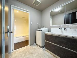 a bathroom with a sink and a washer and dryer at Luxes - 2Br Apt for 10ppl Very Good Location in Hijiyamachō