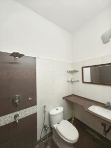 a bathroom with a toilet and a sink at Calcutta Backpackers in Kolkata