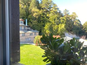 una ventana con vistas a una casa y una planta en Ktima Faki en Litochoro