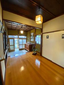 una sala de estar vacía con suelo y ventanas de madera en Guest house Yamabuki - Vacation STAY 13196, en Toyama
