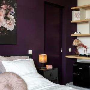 a bedroom with purple walls and a bed with a lamp at K's Torentje in Kruishoutem