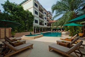 a resort with a pool and chairs and a building at Baan Souy Resort in Pattaya South