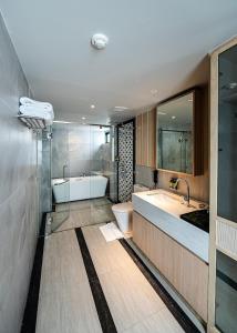 La salle de bains est pourvue d'une baignoire, de toilettes et d'un lavabo. dans l'établissement Floral Court Hotel & Residence Sukhumvit 13, à Bangkok