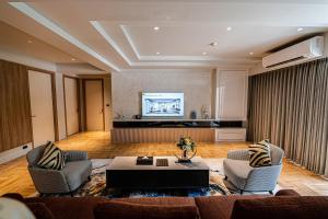 ein Wohnzimmer mit 2 Stühlen und einem Tisch in der Unterkunft Floral Court Hotel & Residence Sukhumvit 13 in Bangkok