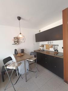 a kitchen with a wooden table and chairs and a counter at Apartamento London Complex Amaya Fuerteventura in Costa de Antigua