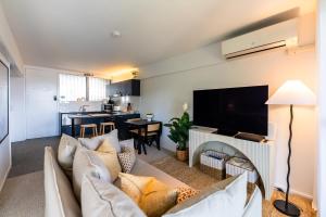 a living room with a couch and a flat screen tv at Riverside Studio apartment in Brisbane