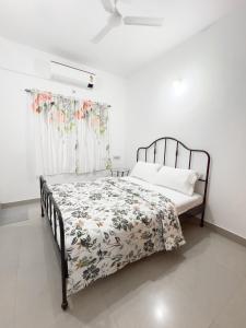 a bedroom with a bed with a floral bedspread at Surya residency in Bangalore