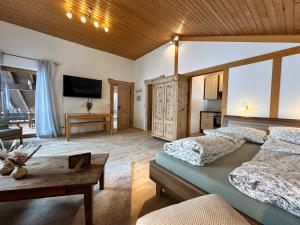 a large bedroom with two beds and a table at Appartement Hochwildfeuerberg in Steingaden
