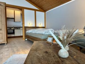 a room with a bed and a table with a vase at Appartement Hochwildfeuerberg in Steingaden