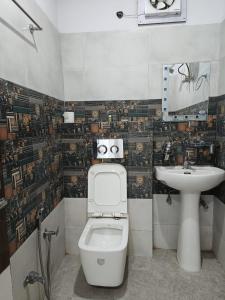 a bathroom with a toilet and a sink at HOTEL TIRATH in Rishīkesh