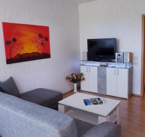 a living room with a couch and a flat screen tv at Ferienwohnung Kurparkblick in Bad Rodach